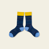 Pair of blue socks with yellow accents on a beige background