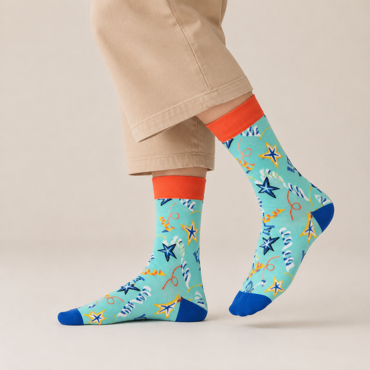 Colorful patterned socks with starfish design worn by a person on a beige background