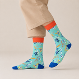 Colorful patterned socks with starfish design worn by a person on a beige background