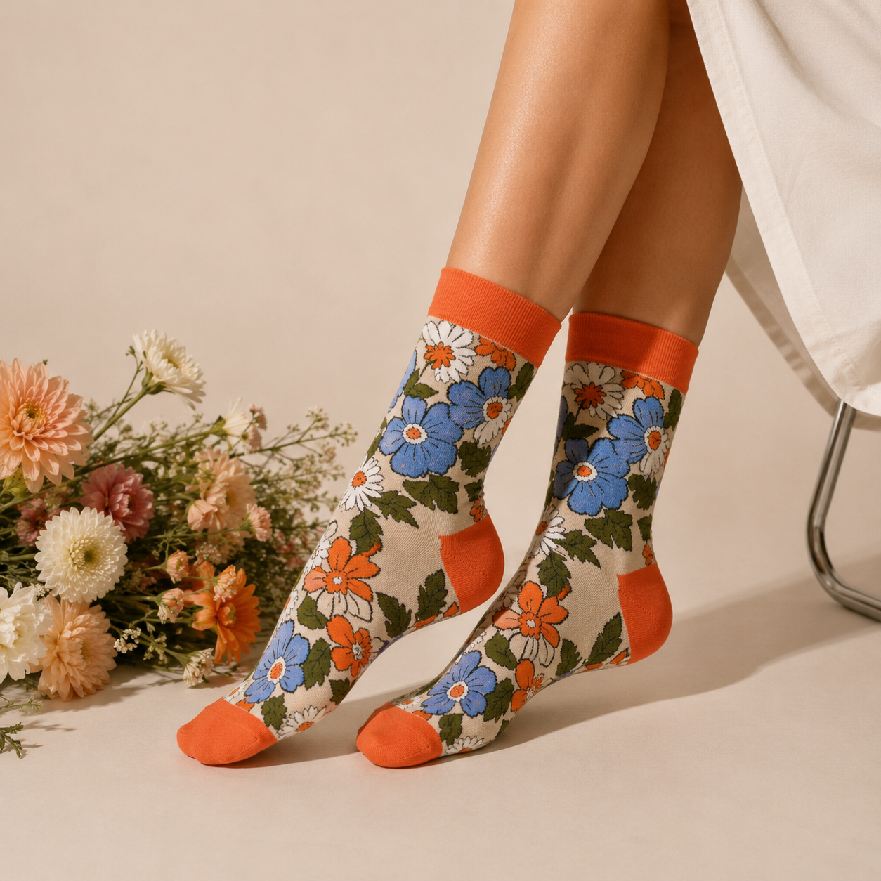 Floral patterned socks with orange accents worn by a person, with flowers in the background.