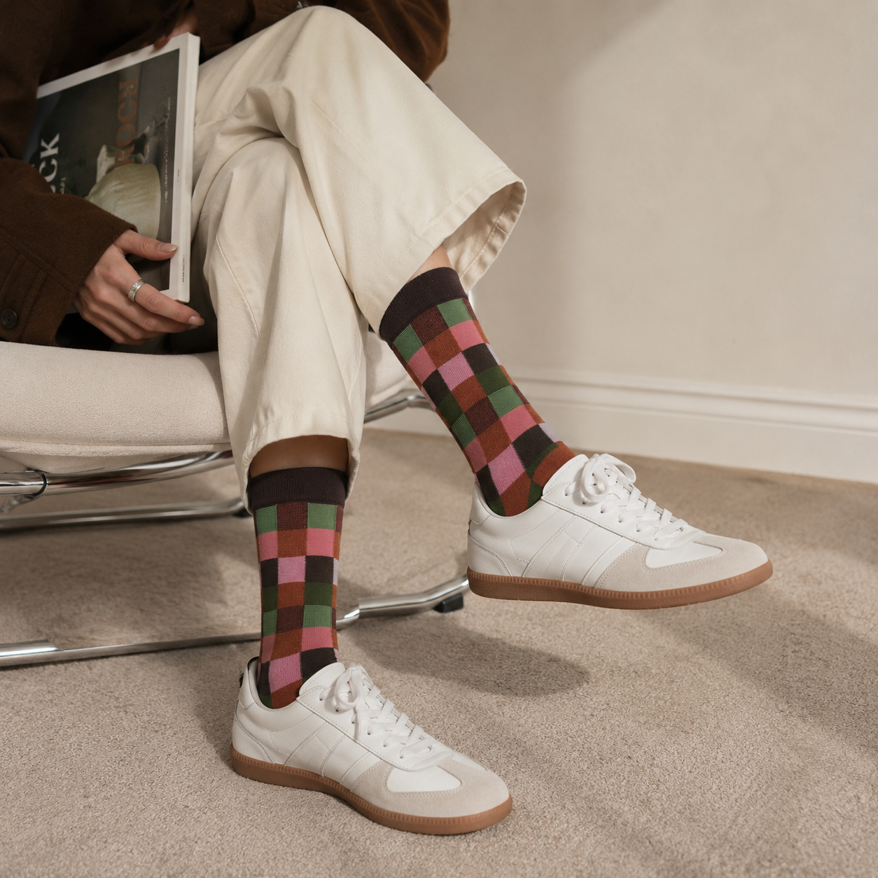 Person wearing patterned socks with white sneakers on a carpeted floor.
