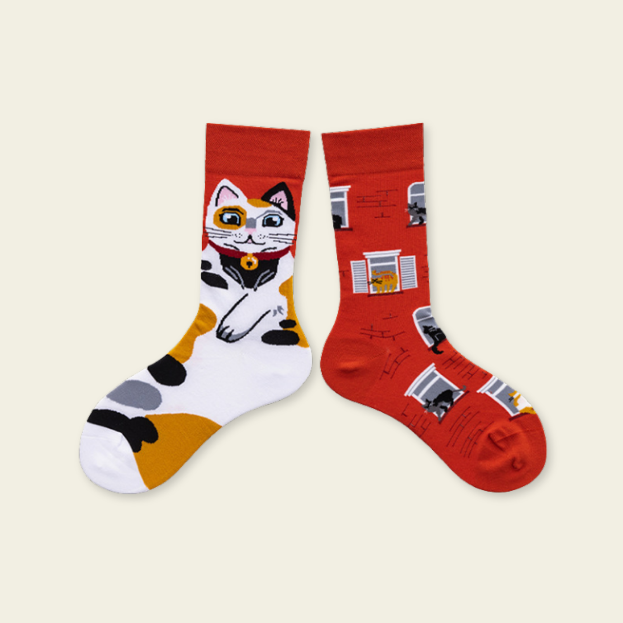 Two socks with cat designs on a beige background