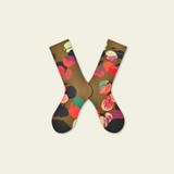 Pair of socks with a colorful fruit pattern on a beige background