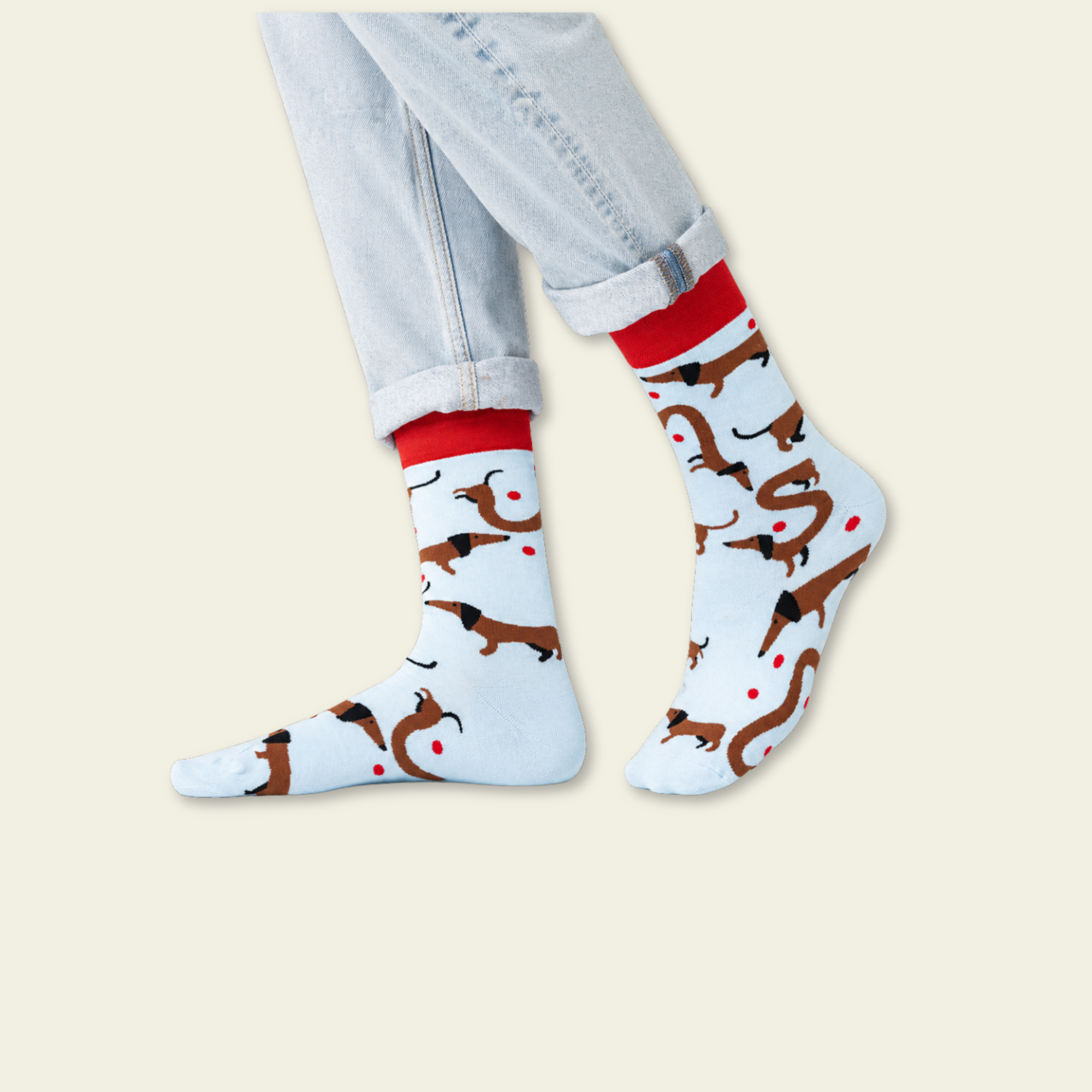 Socks with dog pattern worn with light blue jeans on a beige background