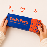 Person holding a 'SocksParti' box with decorative elements on a beige background