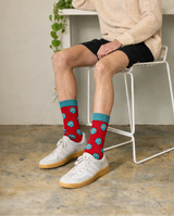 Person wearing red socks with blue accents sitting on a chair indoors.